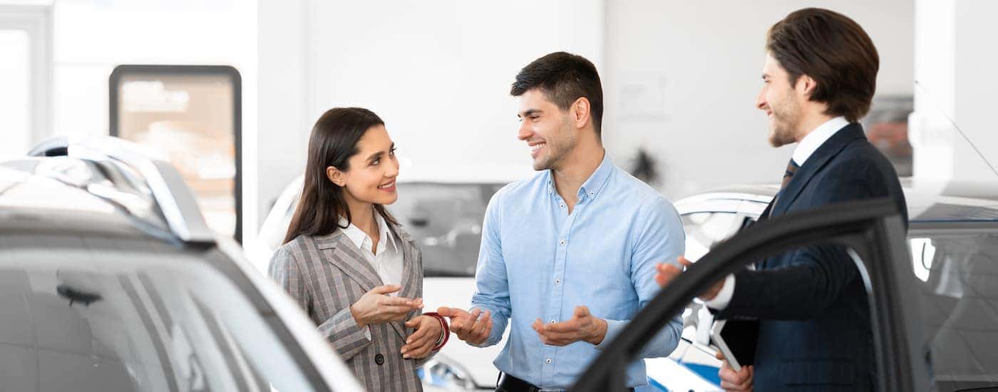A salesman and couple discussing a vehicle.