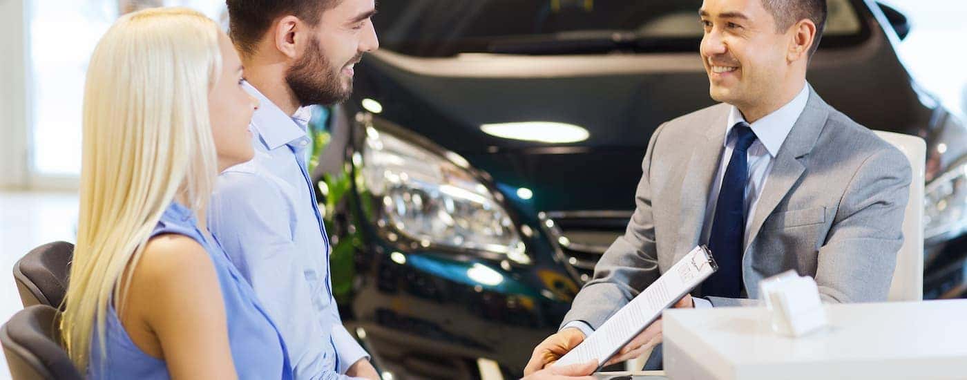 A salesman presenting a deal to a couple.