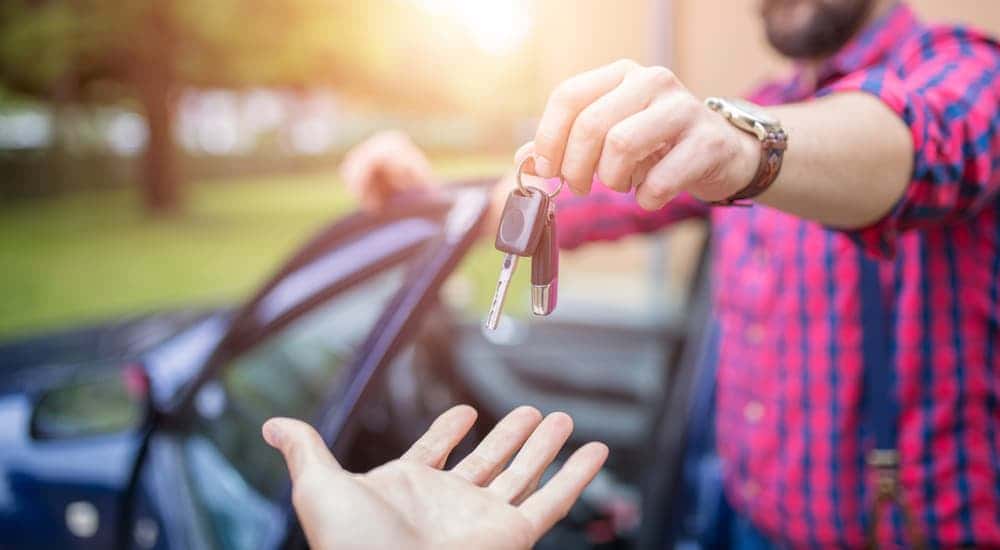 A man handing the keys off to another person.