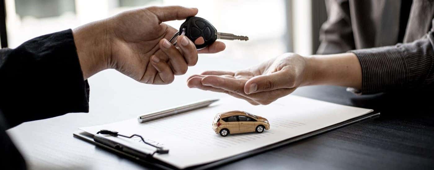 Keys being handed to a customer at a dealership.
