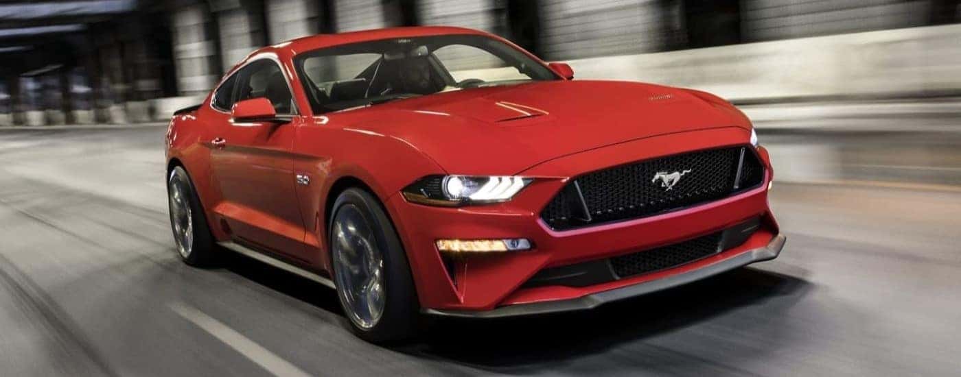 Red 2023 Ford Mustang GT speeding down the road.