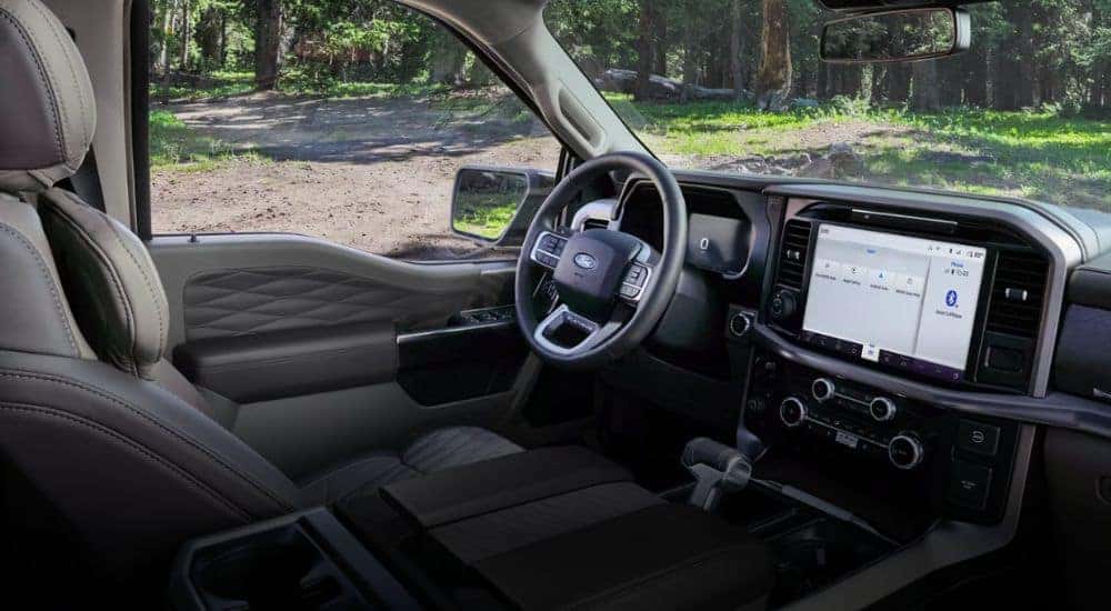 The front interior of a 2026 Ford F-150 XLT showing the infotainment display and steering wheel.