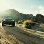 A red 2026 Ford Bronco driving offroad.