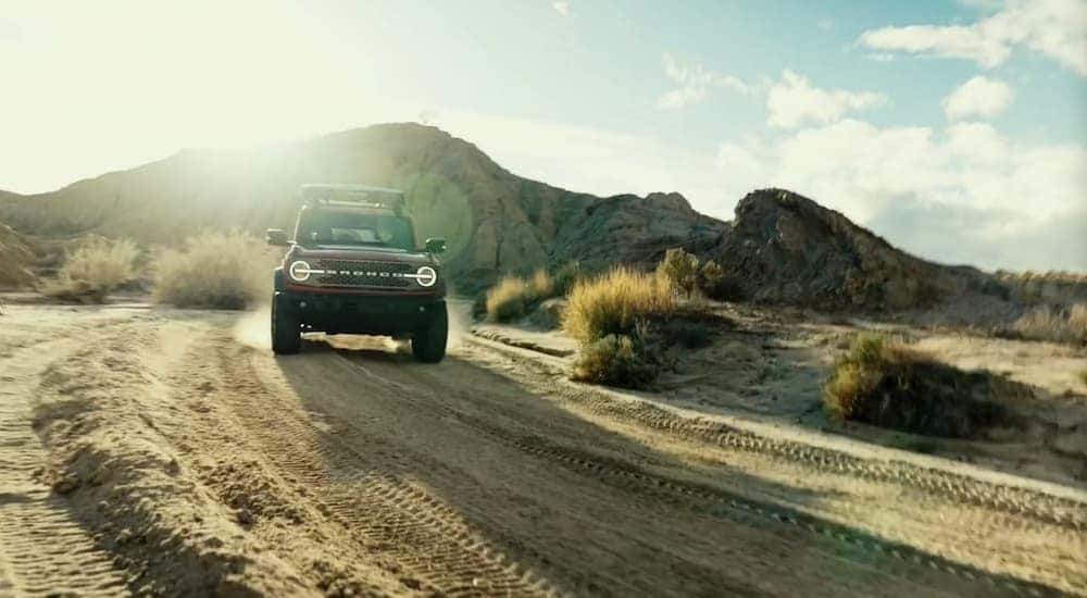 A red 2026 Ford Bronco driving offroad.