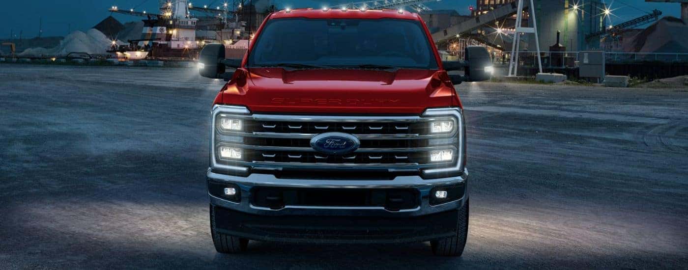 Red 2026 Ford F-250 front view on a construction site at night.