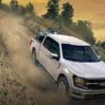 White 2026 Ford F-150 driving off-road downhill.