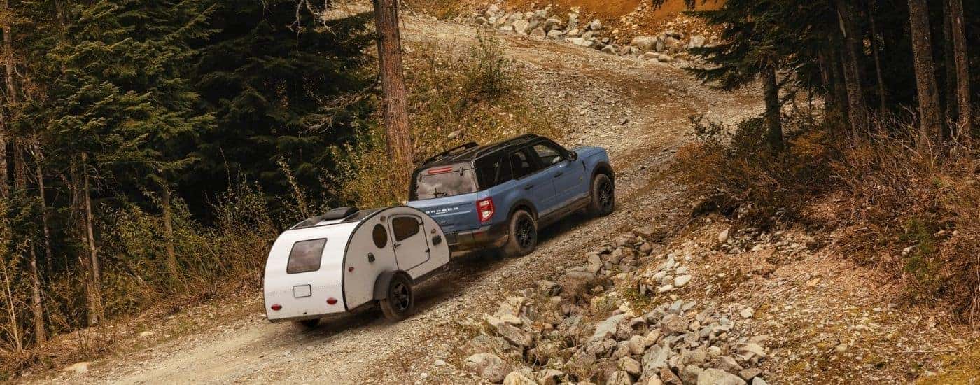 Blue 2025 Ford Bronco Sport Badlands towing a camoer