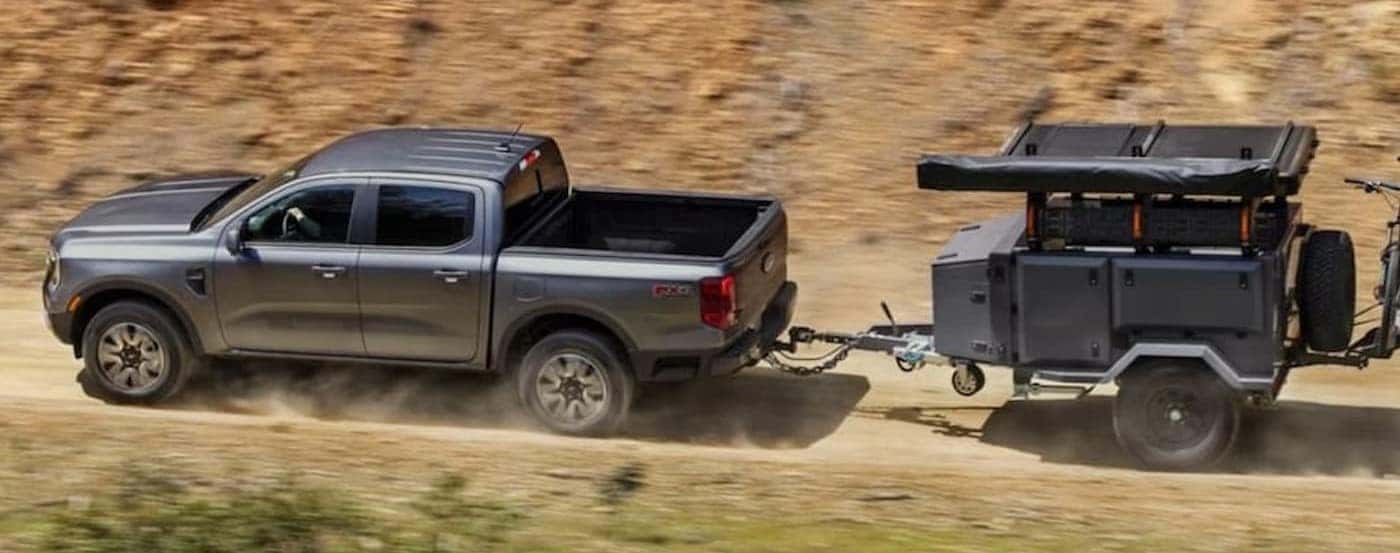 A silver 2026 Ford Ranger towing a trailer.