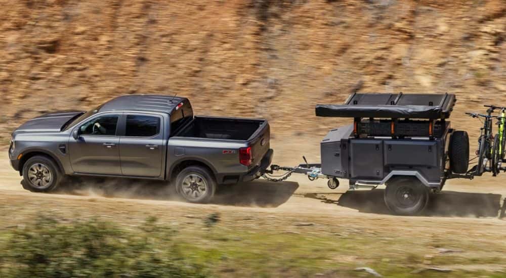 A gray 2026 Ford Ranger Raptor towing a trailer.