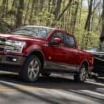 A red 2020 Ford F-150 towing a boat.