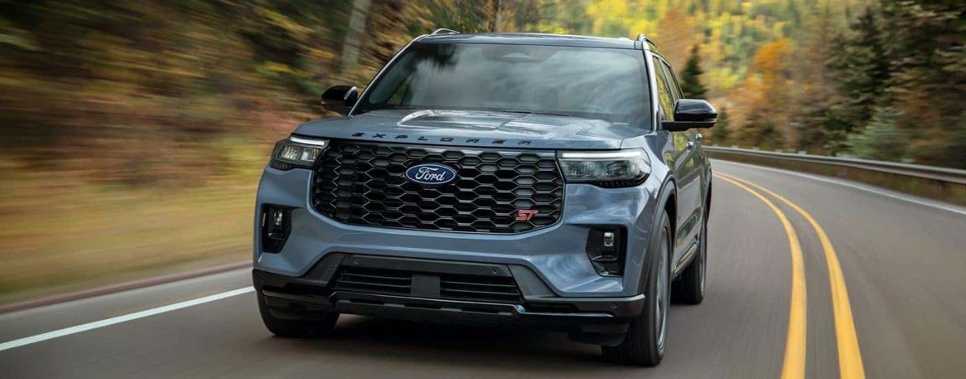 Blue 2027 Ford Explorer ST driving on a paved road.