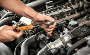 Man tightening bolt on engine