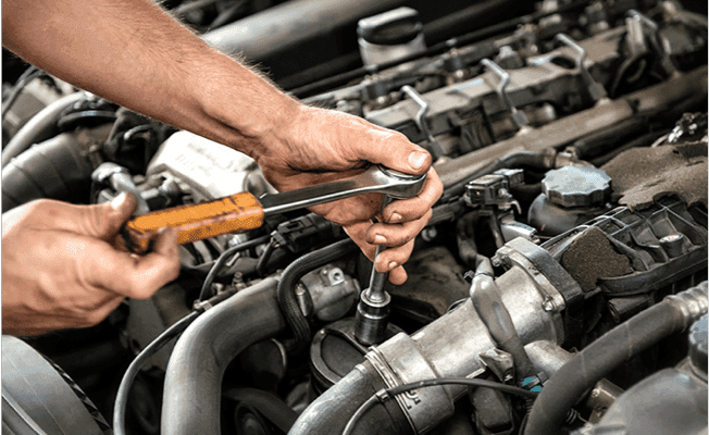 Man tightening bolt on engine