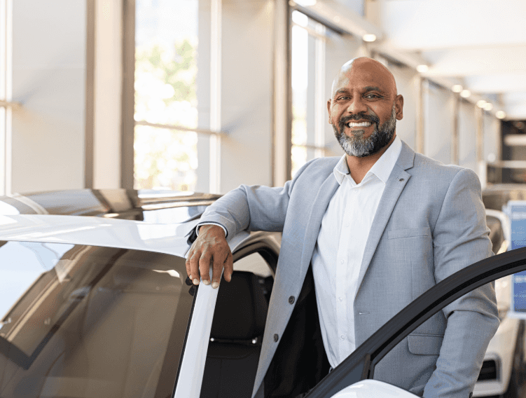 Man standing at car smiling