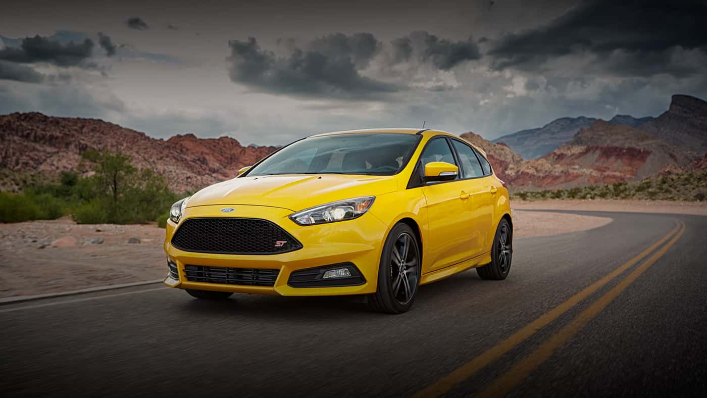 Yellow Ford Focus Driving Down a Road