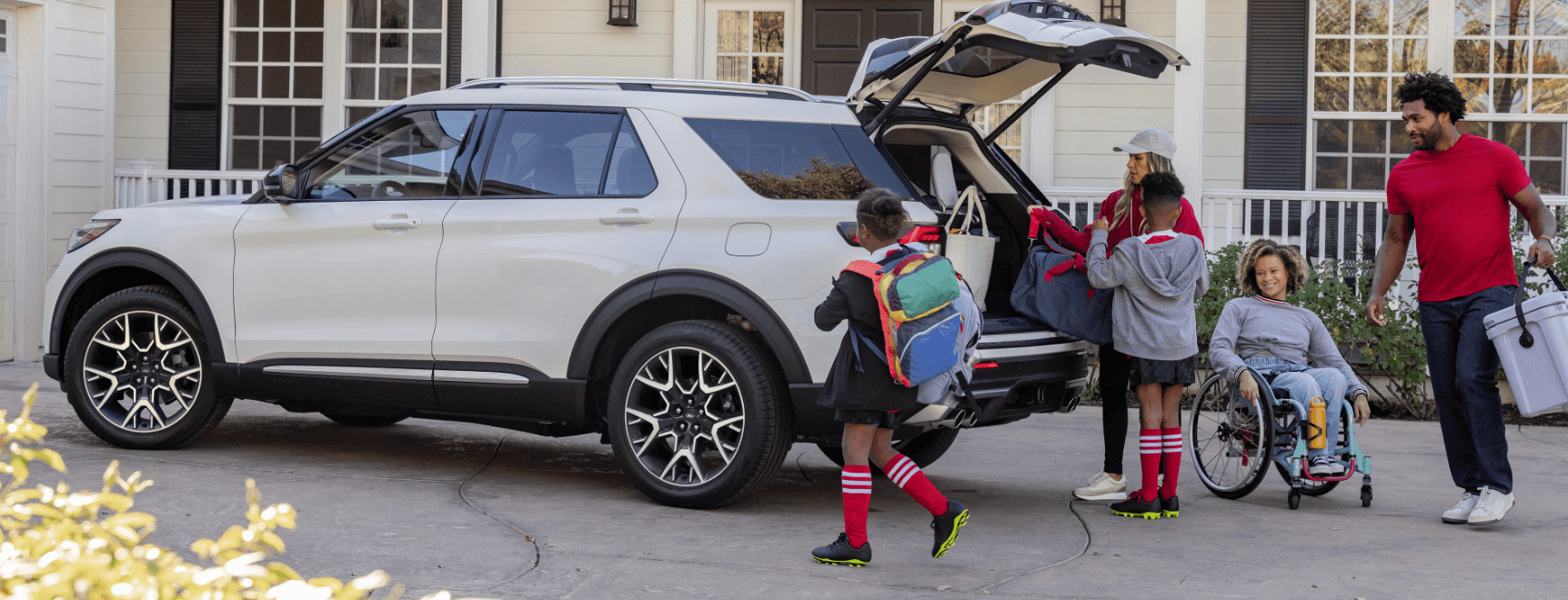 Family loading gear into 2025 Ford Explorer SUV.