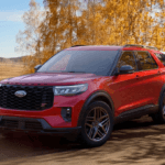 Red 2026 Ford Explorer driving on a scenic fall road for Ford of Cookeville.