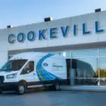 Ford Mobile Service van parked outside the Ford of Cookeville dealership building on a sunny day, with a large “Cookeville” sign above the entrance.