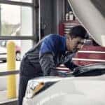 Ford service tech working under the hood of a car
