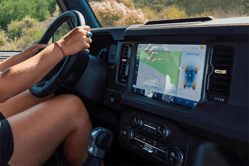 Ford Bronco interior dashboard with someone in the passenger seat