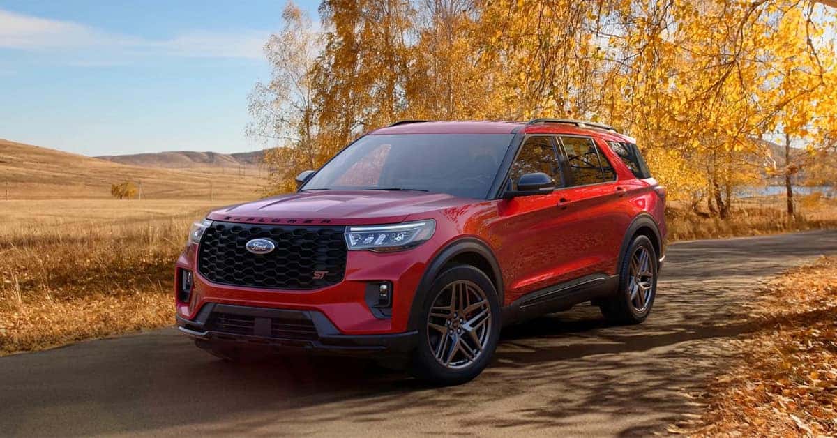2026 Ford Explorer parked on a paved road lined with vibrant golden autumn trees and rolling fields.
