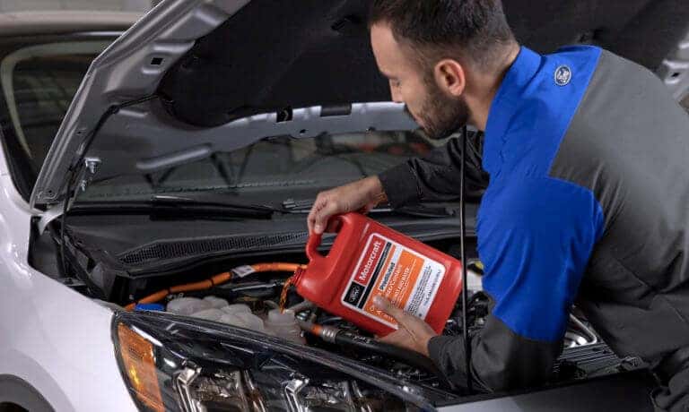 Ford Service technician pouring oil