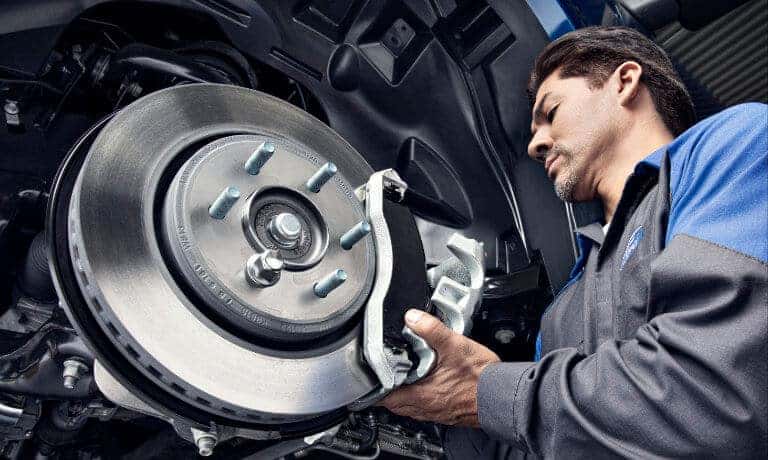 Ford Service technician inspecting brakes