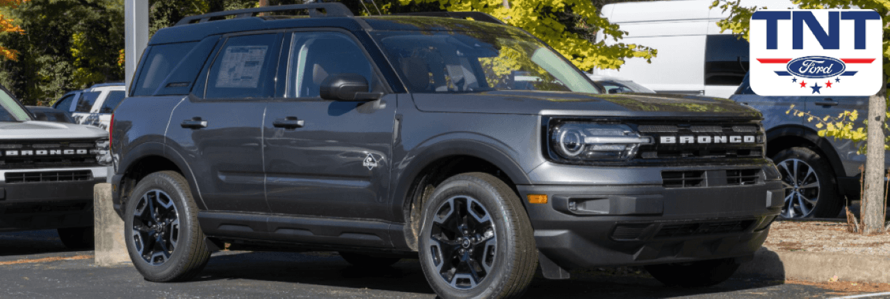 A sleek new Ford Bronco parked in a rural setting, showcasing its rugged design and capability, perfect for Iowa drives.