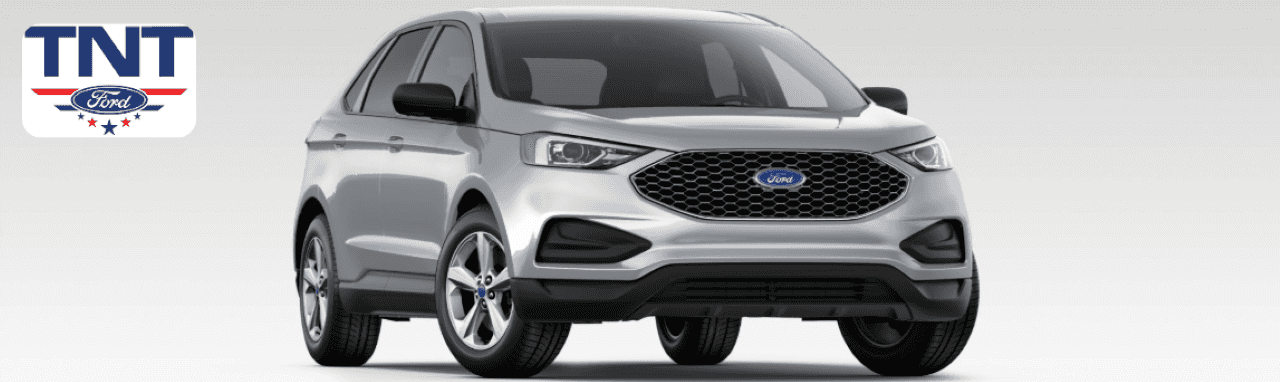 Customer reviewing a used Ford Edge with a sales expert at the TNT Ford showroom