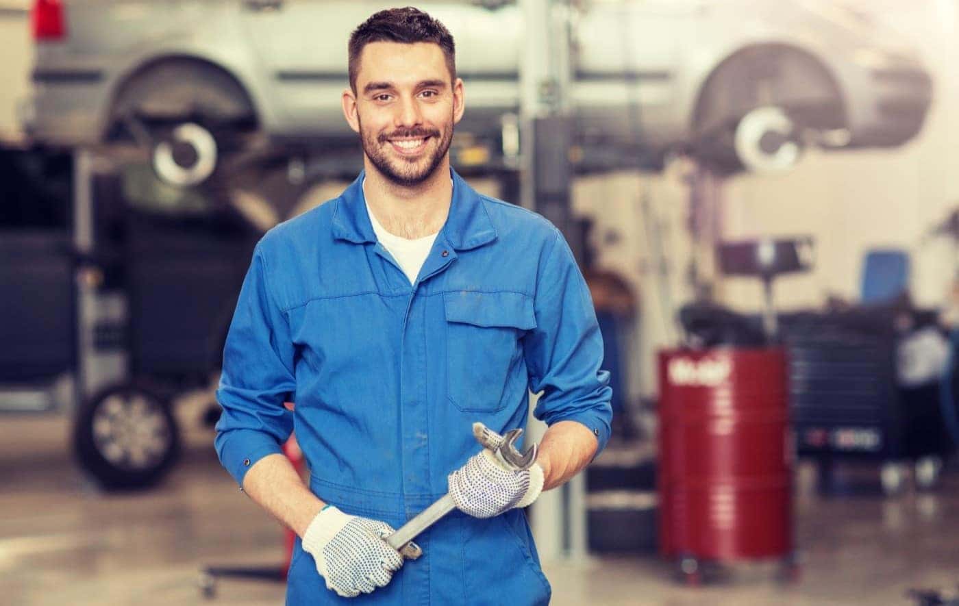 Ford mechanic holding a wrench about to work on a vehicle