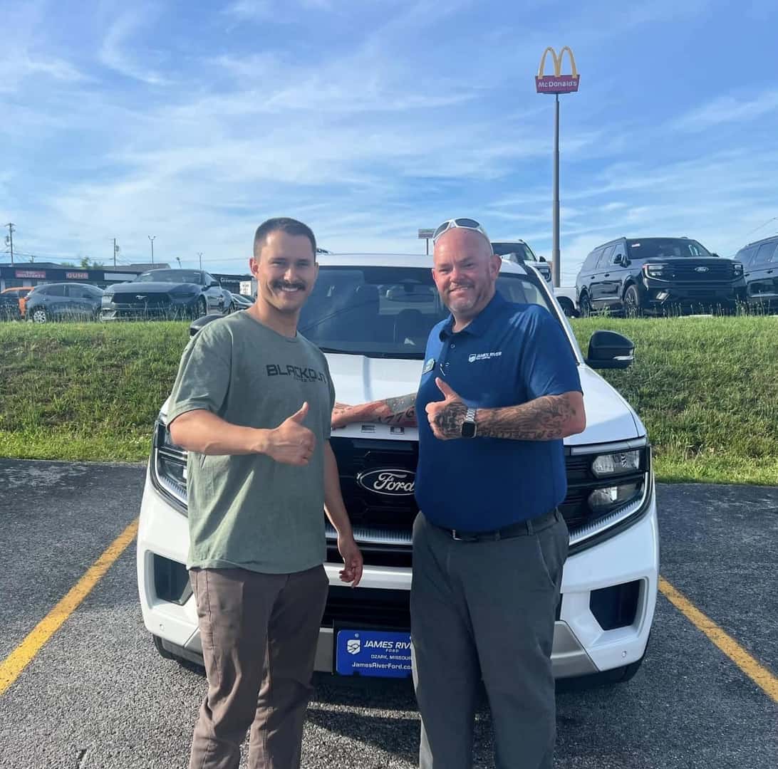 two men standing in front of white suv