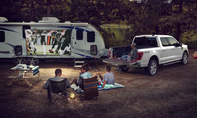 2026 Ford F-150 parked with an RV in forest