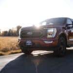 Red Ford F-150 Driving during dusk near farmland