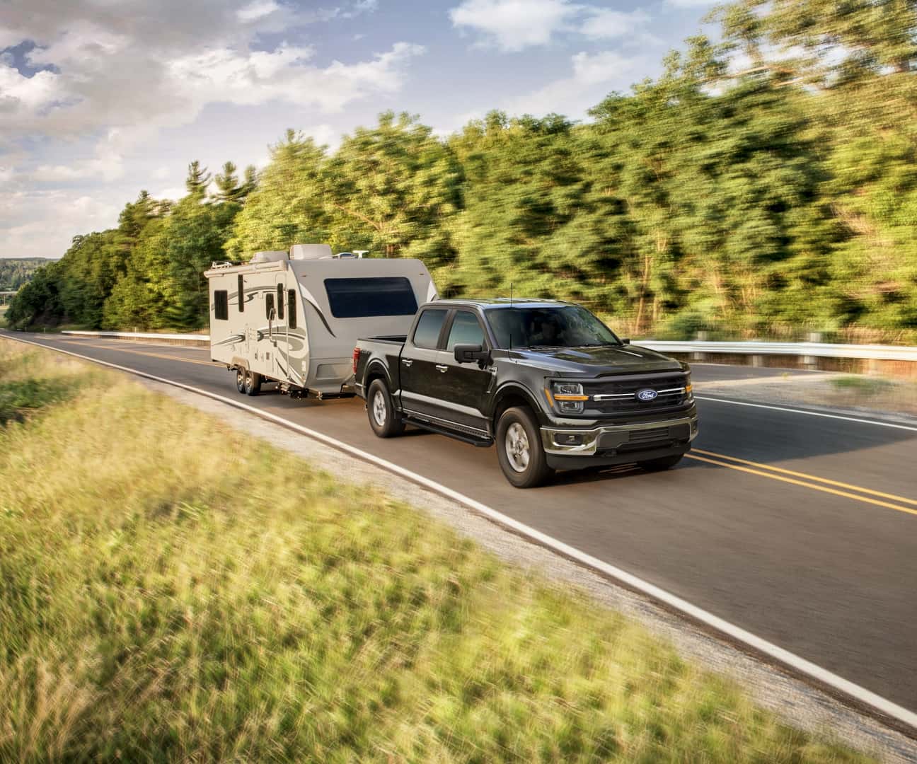 Ford F-150 pulling a trailer on a backcountry road
