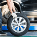 Stock image of a technican taking off a tire on a car