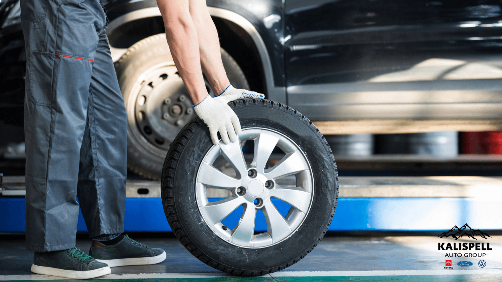 Stock image of a technican taking off a tire on a car