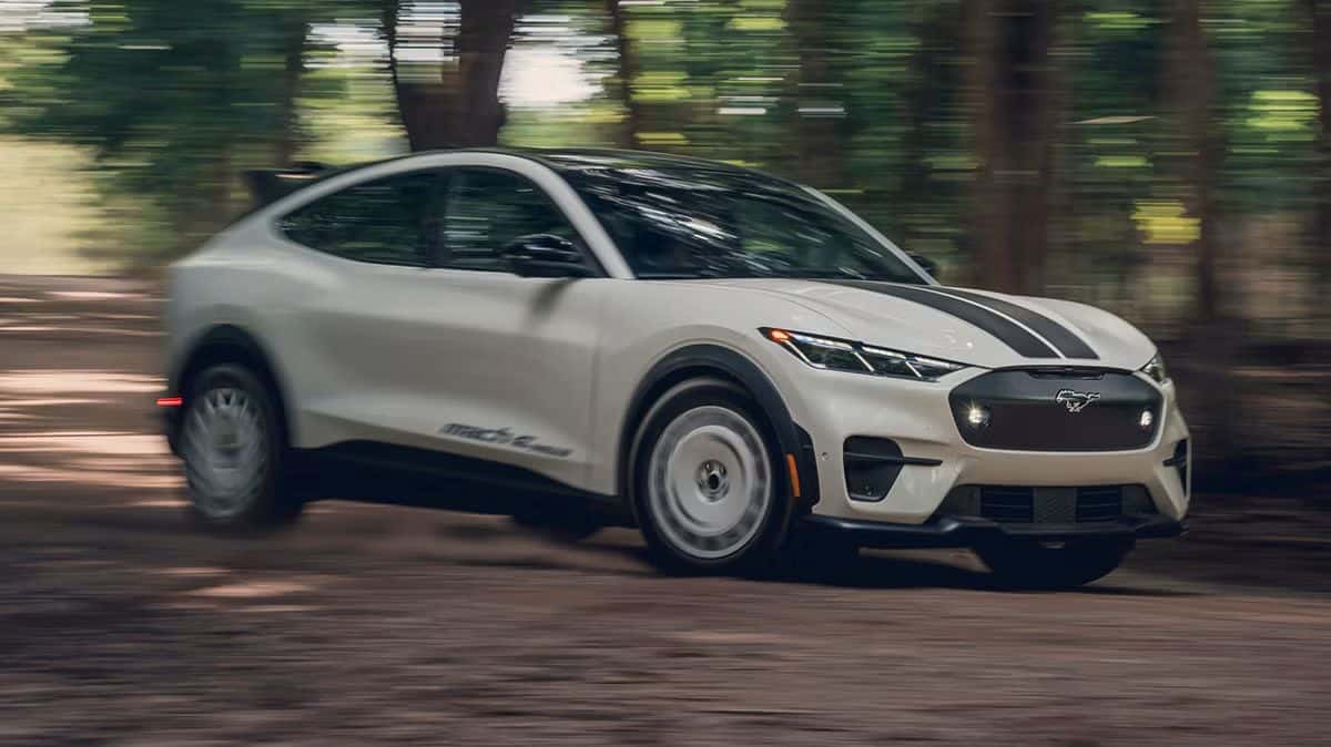 2026 Ford Mustang Mach-E driving down a dirt road in a forest