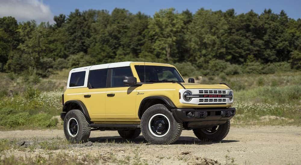 A yellow 4-door 2024 Ford Bronco Heritage Limited Edition parked off-road.