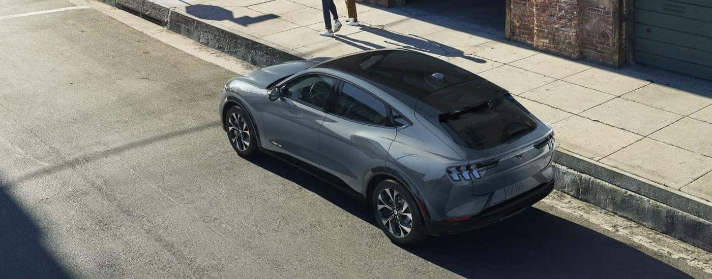 High angle view of a grey 2024 Ford Mustang Mach-E parked by a curb.