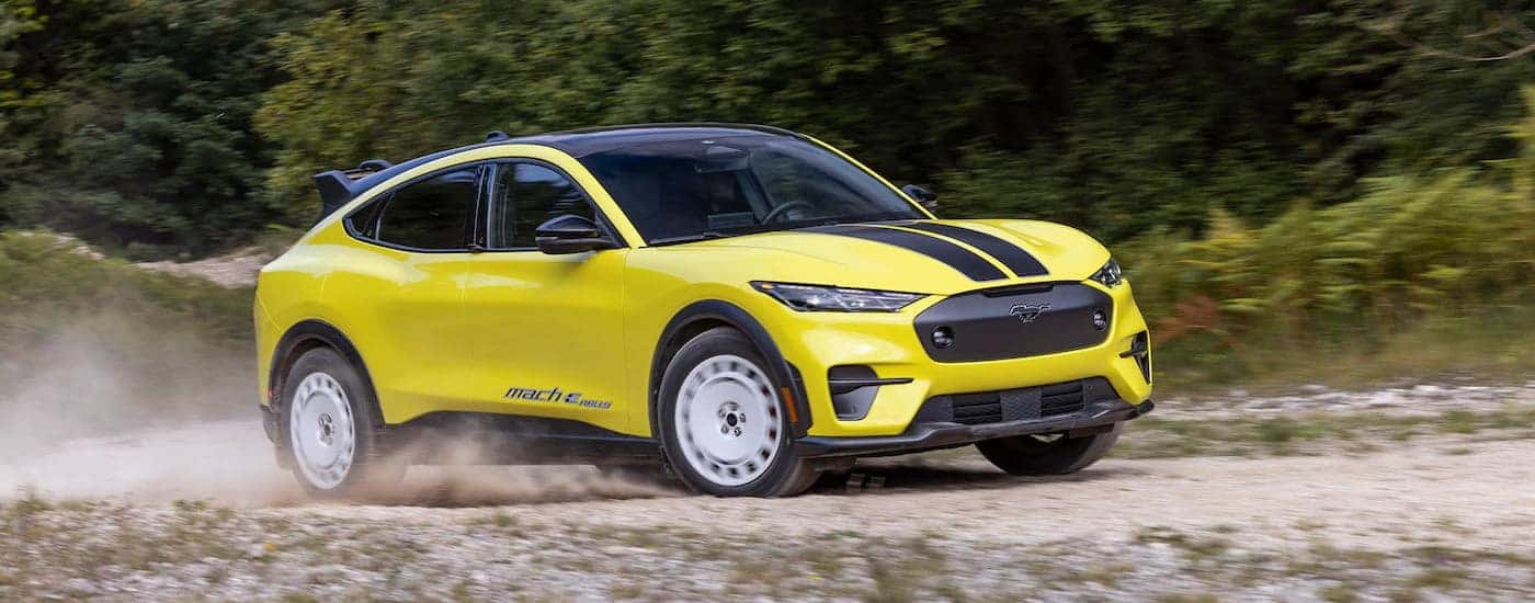 A yellow 2024 Ford Mustang Mach-E GT Rally Edition driving off-road.