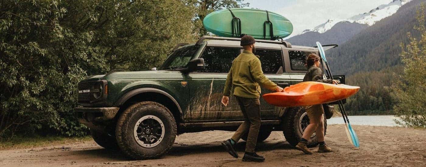 A green 2025 Ford Bronco Badlands parked near a lake.