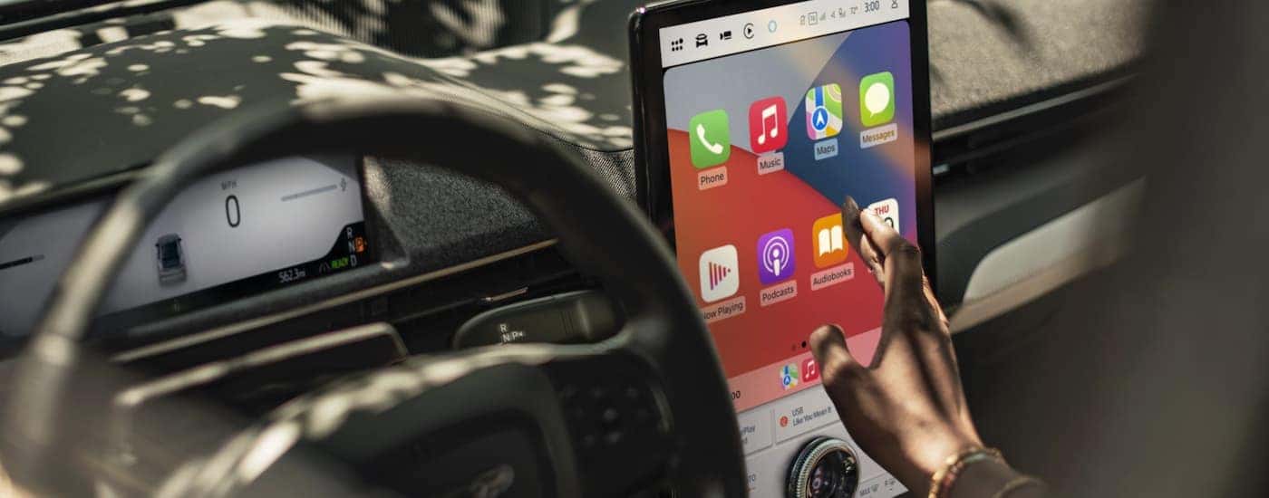 A person is using the infotainment screen in a 2025 Ford Mustang Mach-E.