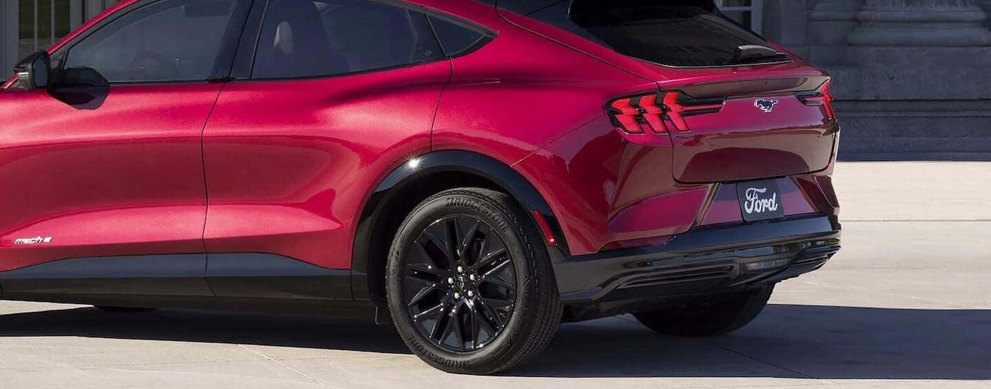 A red 2025 Ford Mustang Mach-E Premium Sport parked on concrete.