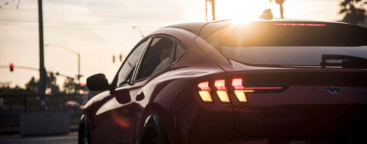 A red 2025 Mustang Mach-E for sale near Salinas is shown form the rear.