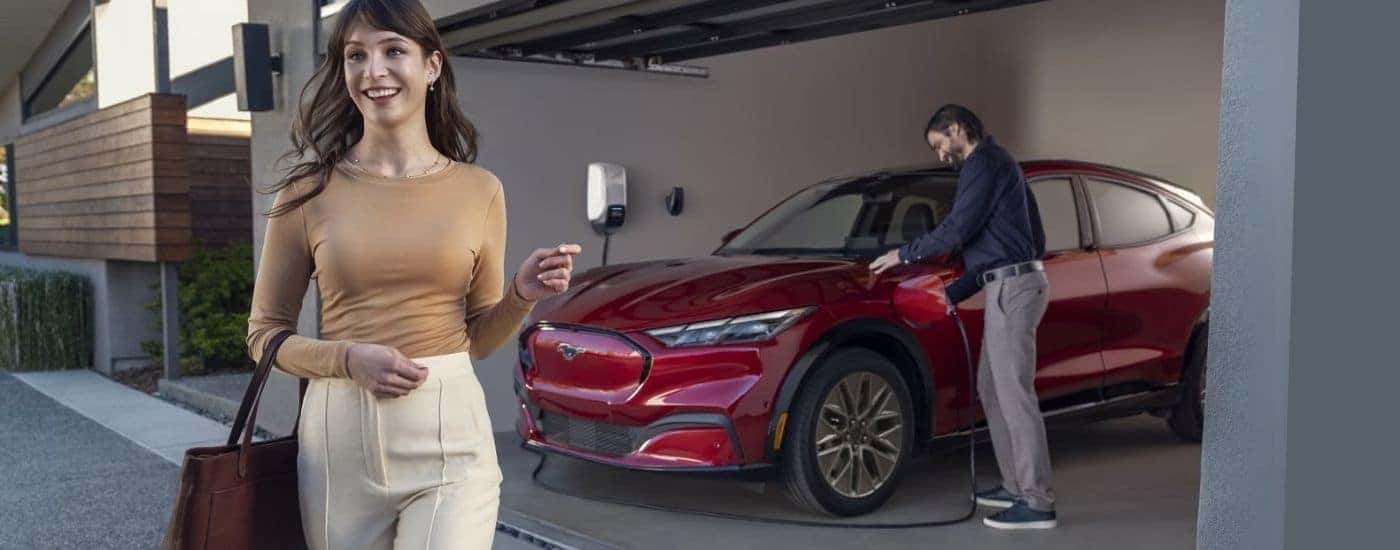 A red 2025 Ford Mustang Mach-E is charging in a garage.