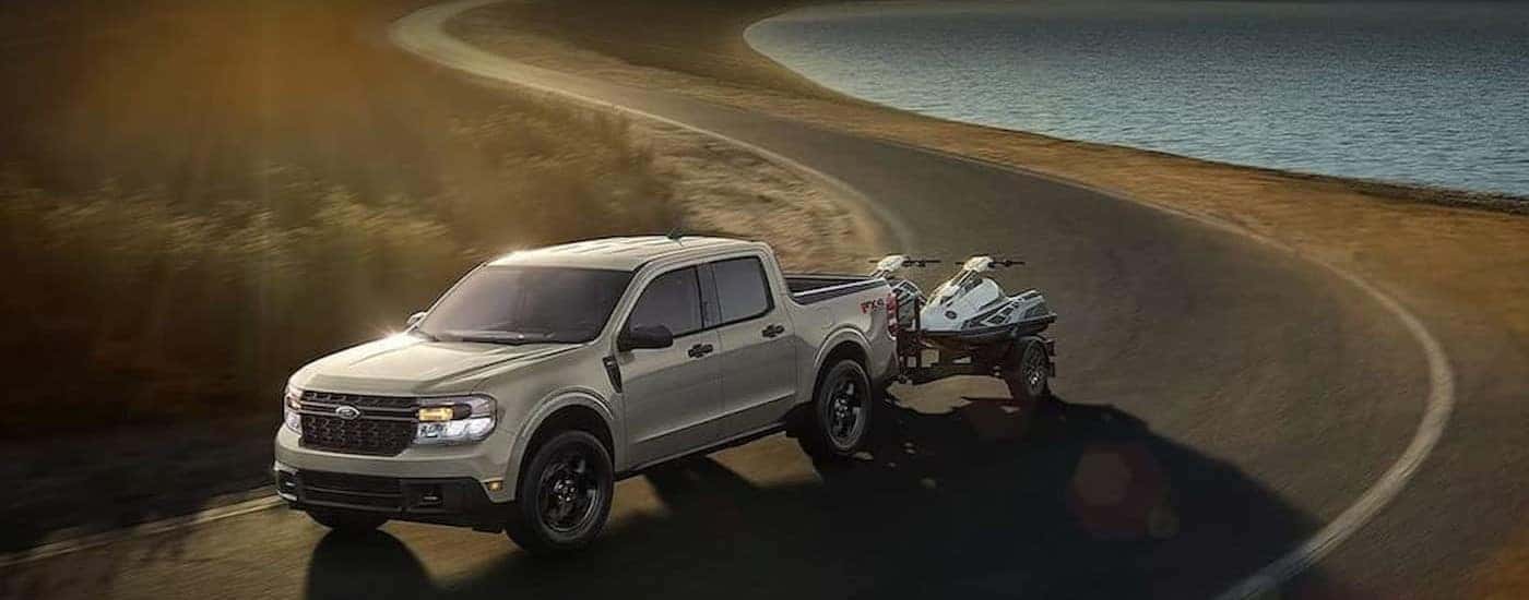 A silver 2024 Ford Maverick towing a trailer to a Ford dealer near Los Gatos.