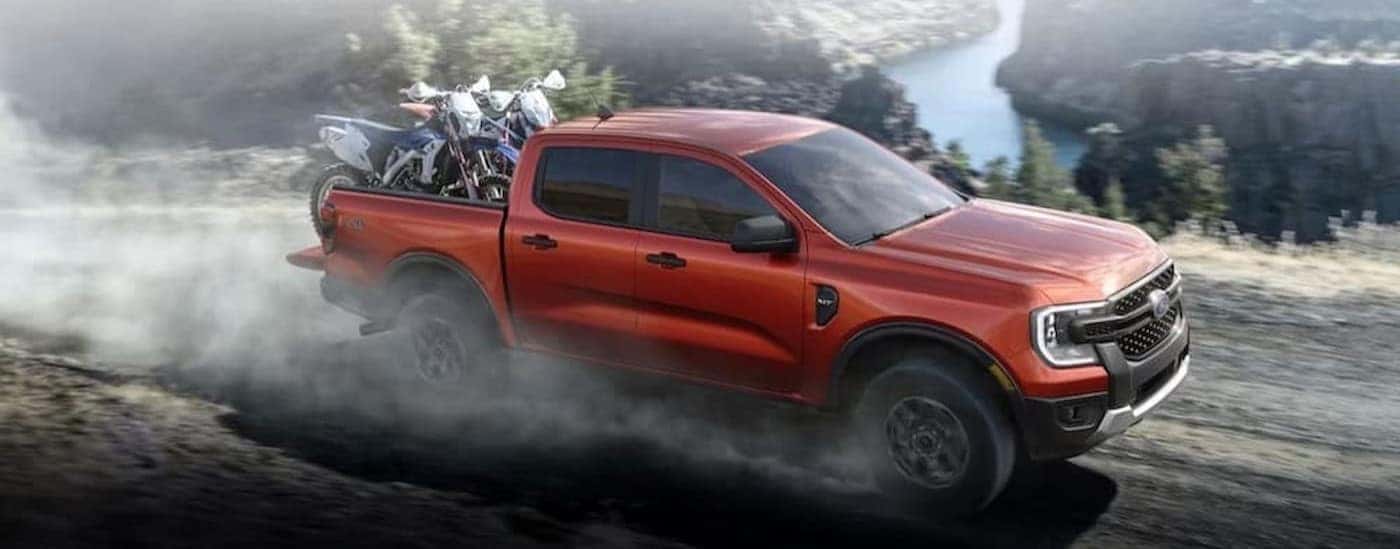 A red 2024 Ford Ranger driving off-road.