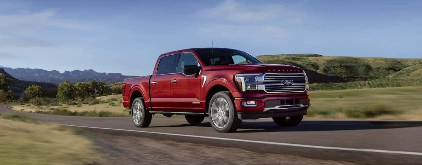A red 2025 Ford F-150 Platinum driving to a Ford dealer near Campbell.