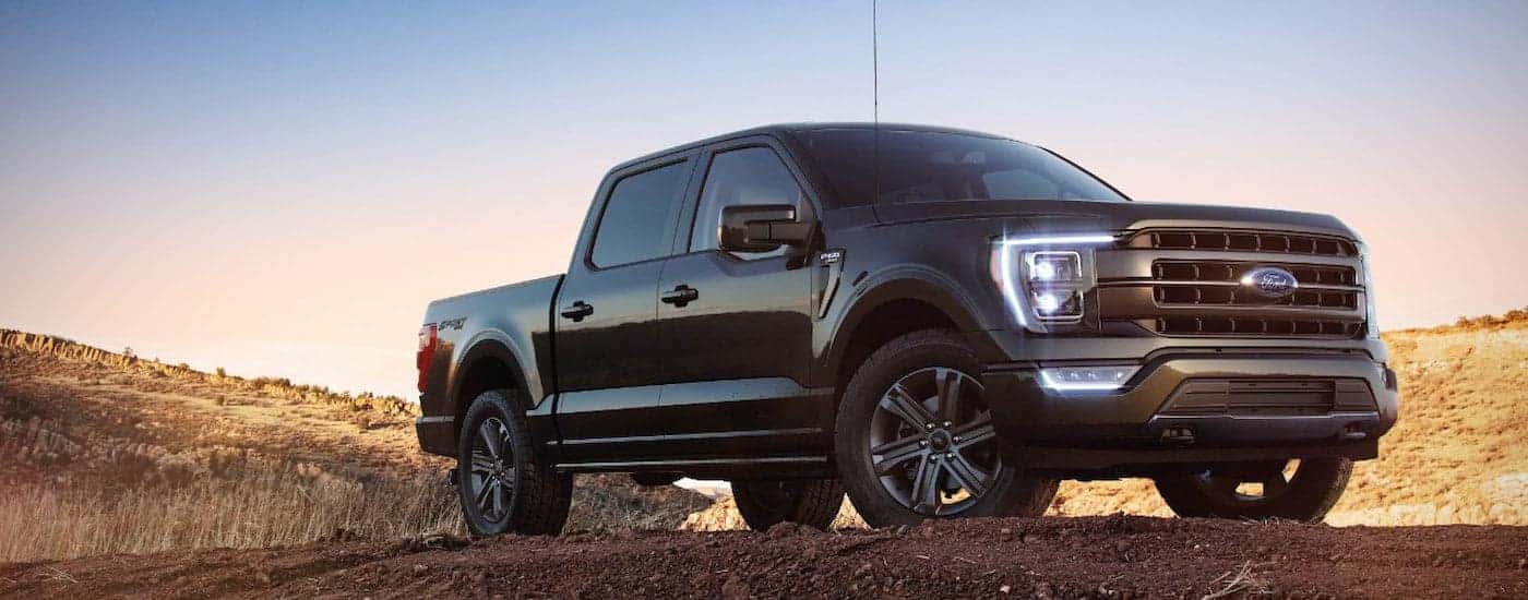 A black 2022 Ford F-150 XL Sport parked off-road after visiting a dealer with a Ford F-150 for sale.