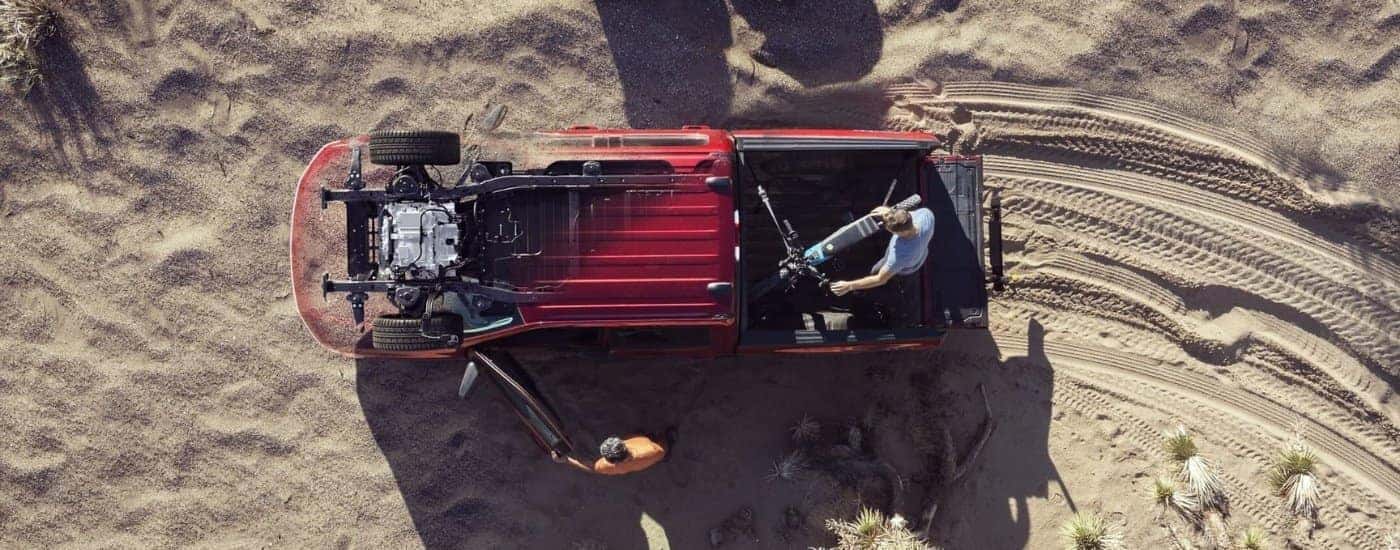 Bike in the bed of a red 2024 Ford F-150 Lightning off-road.